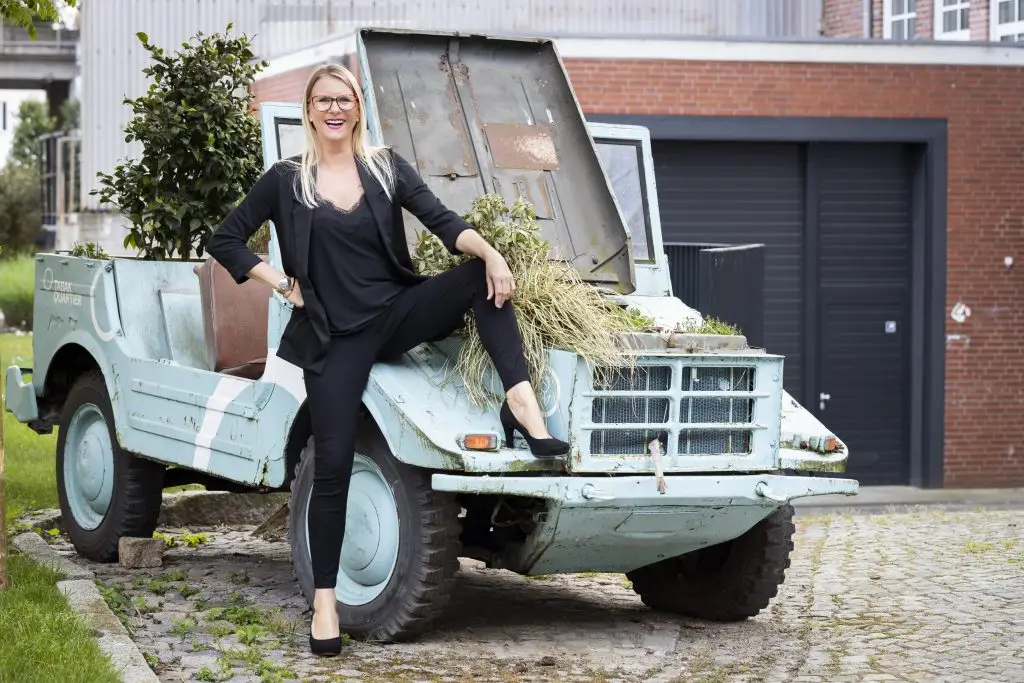 Vertriebstraining und Webseiten aus Bremen. Stefanie Schnakenberg auf einem Auto sitzend.